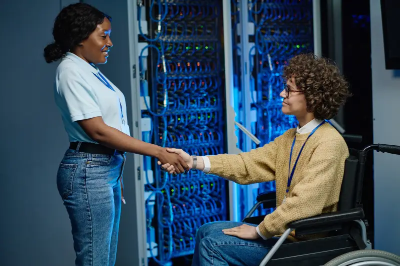 Engineer greeting a client in a server room
